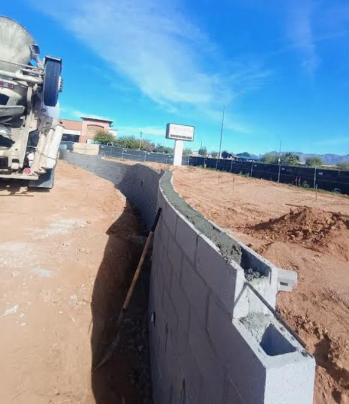 Concrete being poured into curved CMU retaining wall at Bikini Beans Coffee commercial project Scottsdale AZ