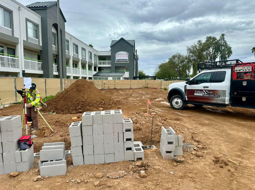 Father and Son Masonry truck and surveying crew at CMU block construction site for Bikini Beans Coffee Scottsdale AZ