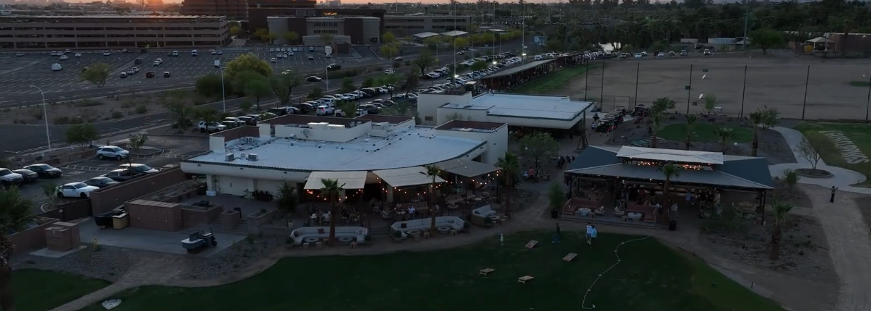 Aerial drone view of completed Grass Clippings Rolling Hills restaurant and event venue in Arizona at dusk