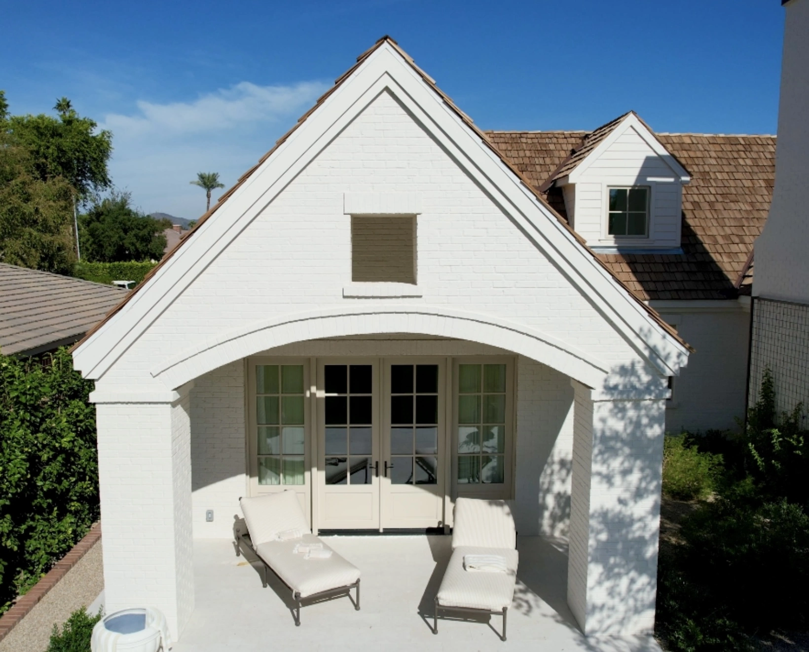 Covered brick patio with arched entrance and French doors on luxury home in Phoenix AZ
