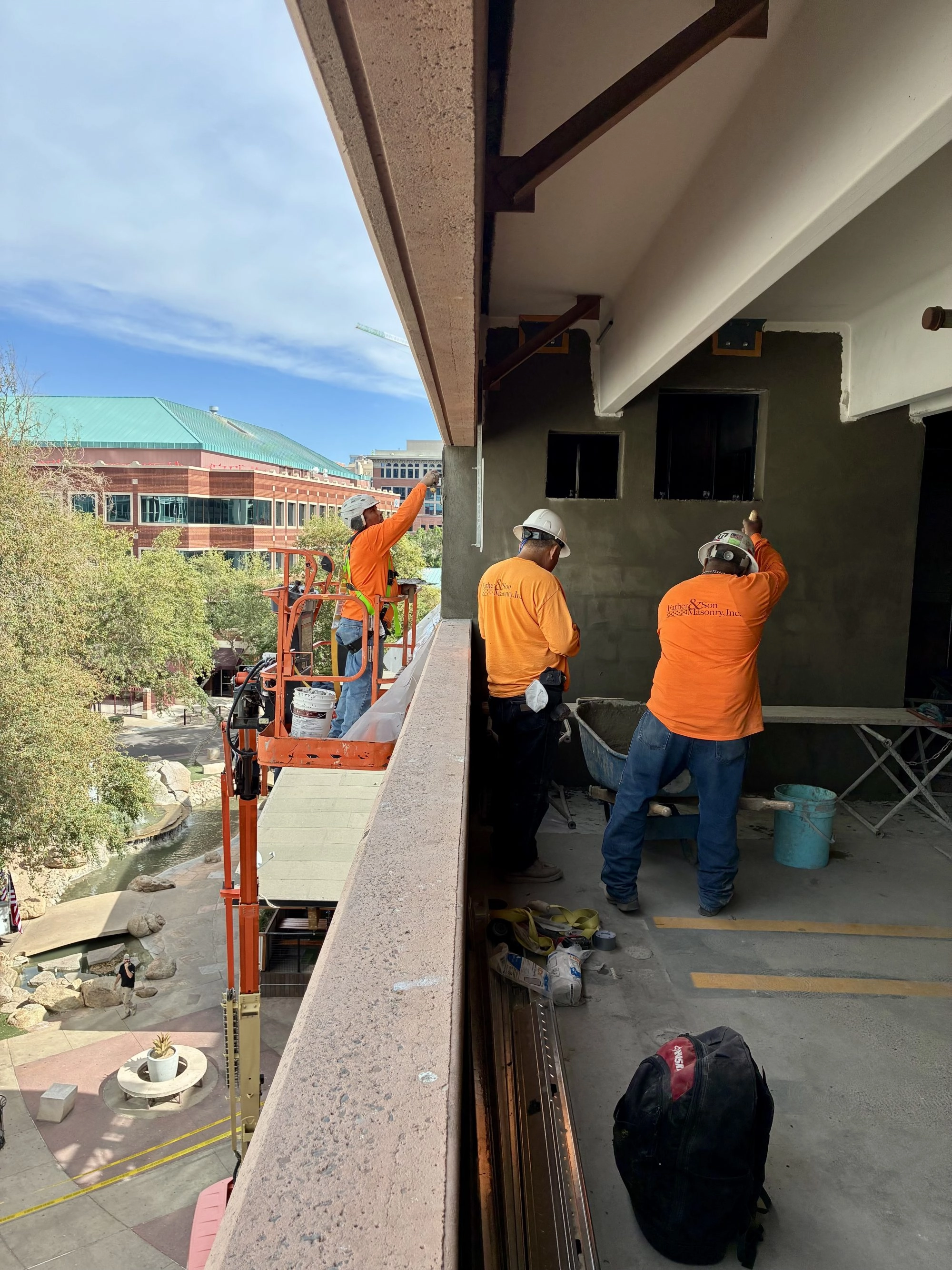 Father and Son Masonry crew applying stucco on upper level of JP Morgan Chase parking garage Tempe AZ