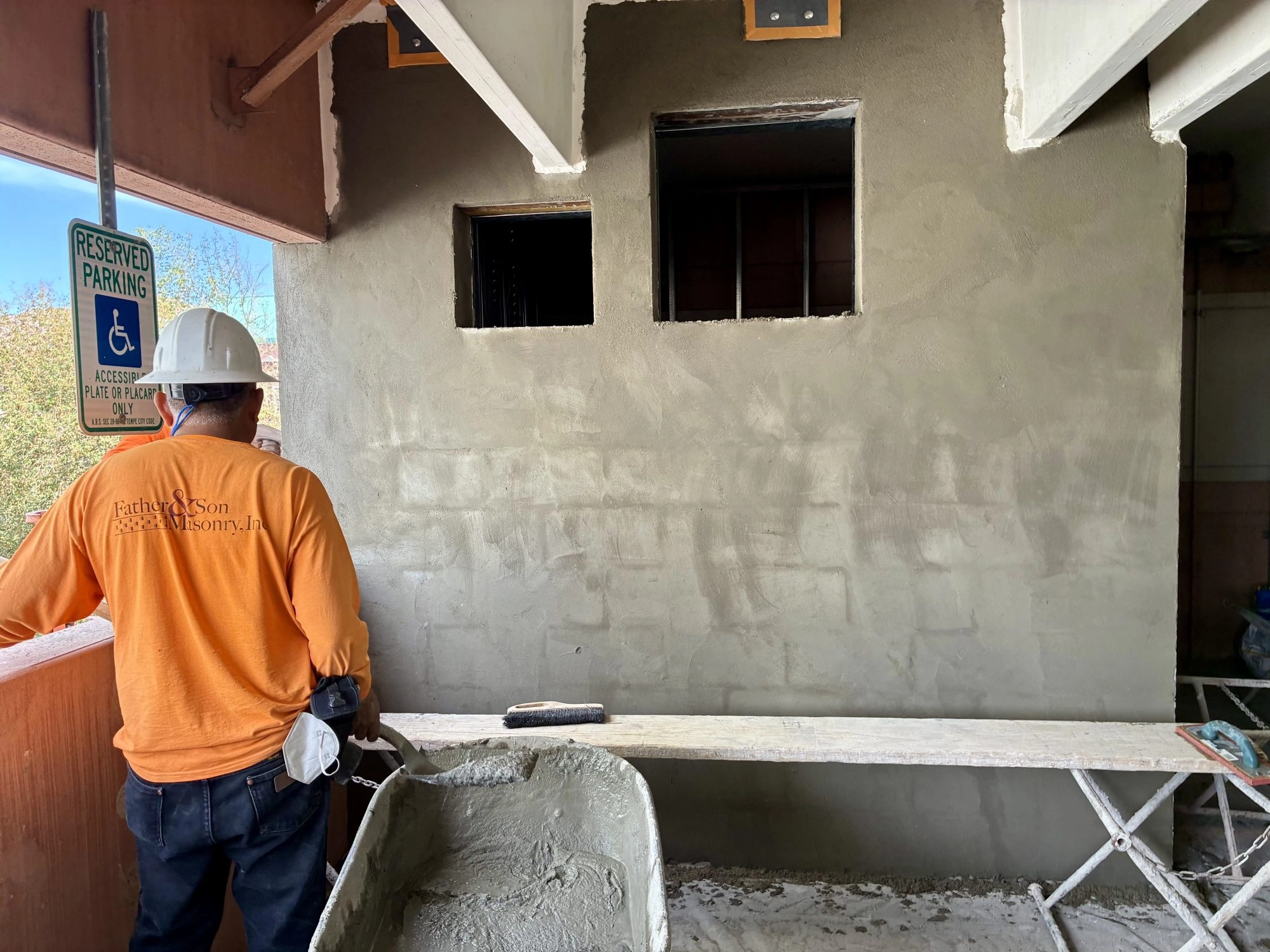Father and Son Masonry worker finishing stucco on CMU wall at JP Morgan Chase parking structure Tempe AZ