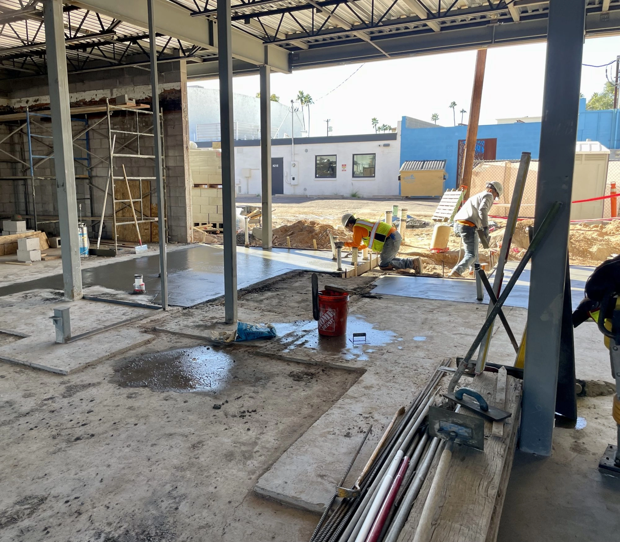 Father and Son Masonry crew pouring interior concrete slab at Reformed Pilates renovation in Old Town Scottsdale AZ