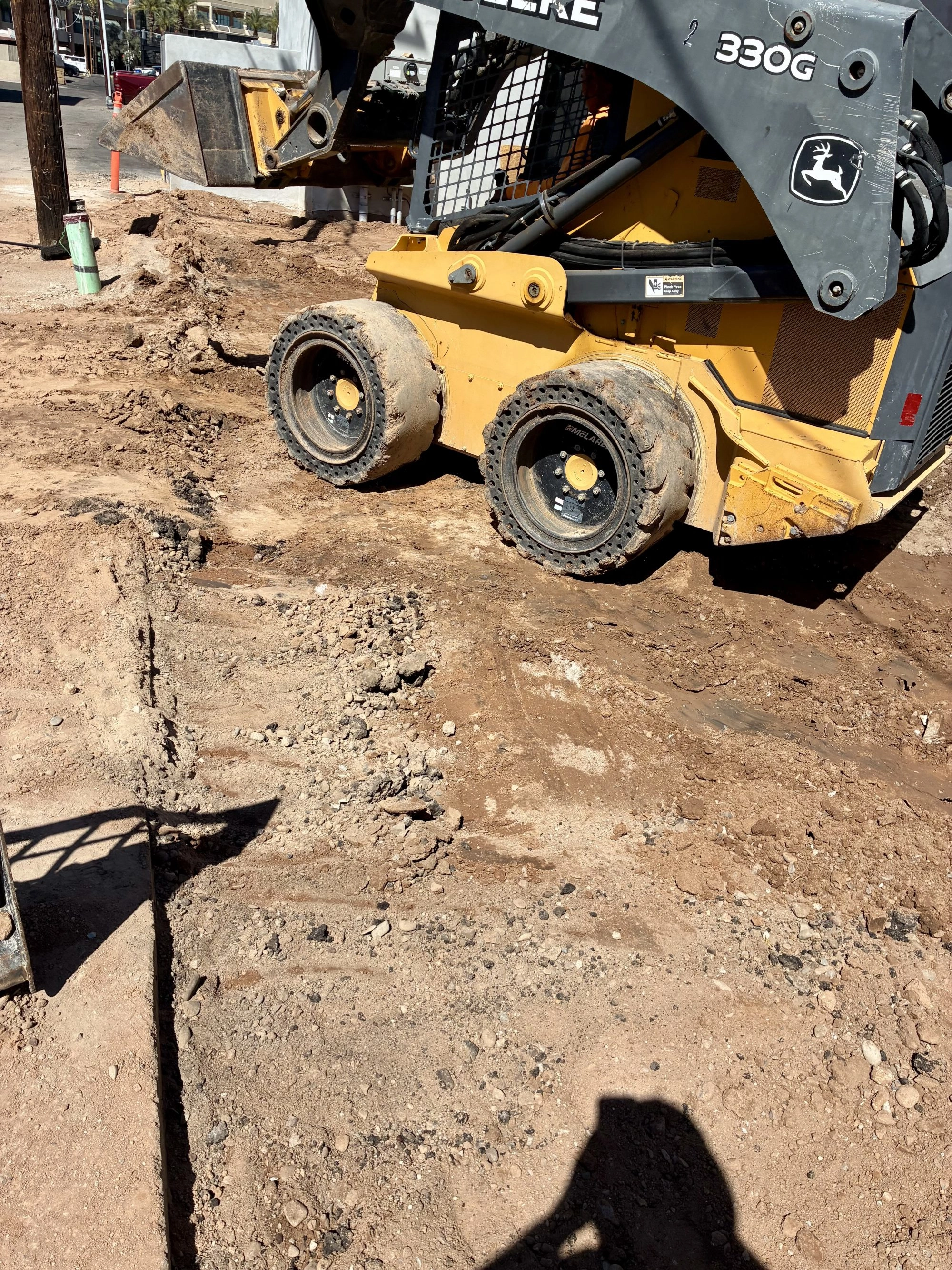 John Deere skid steer excavating site during Reformed Pilates commercial renovation in Old Town Scottsdale AZ