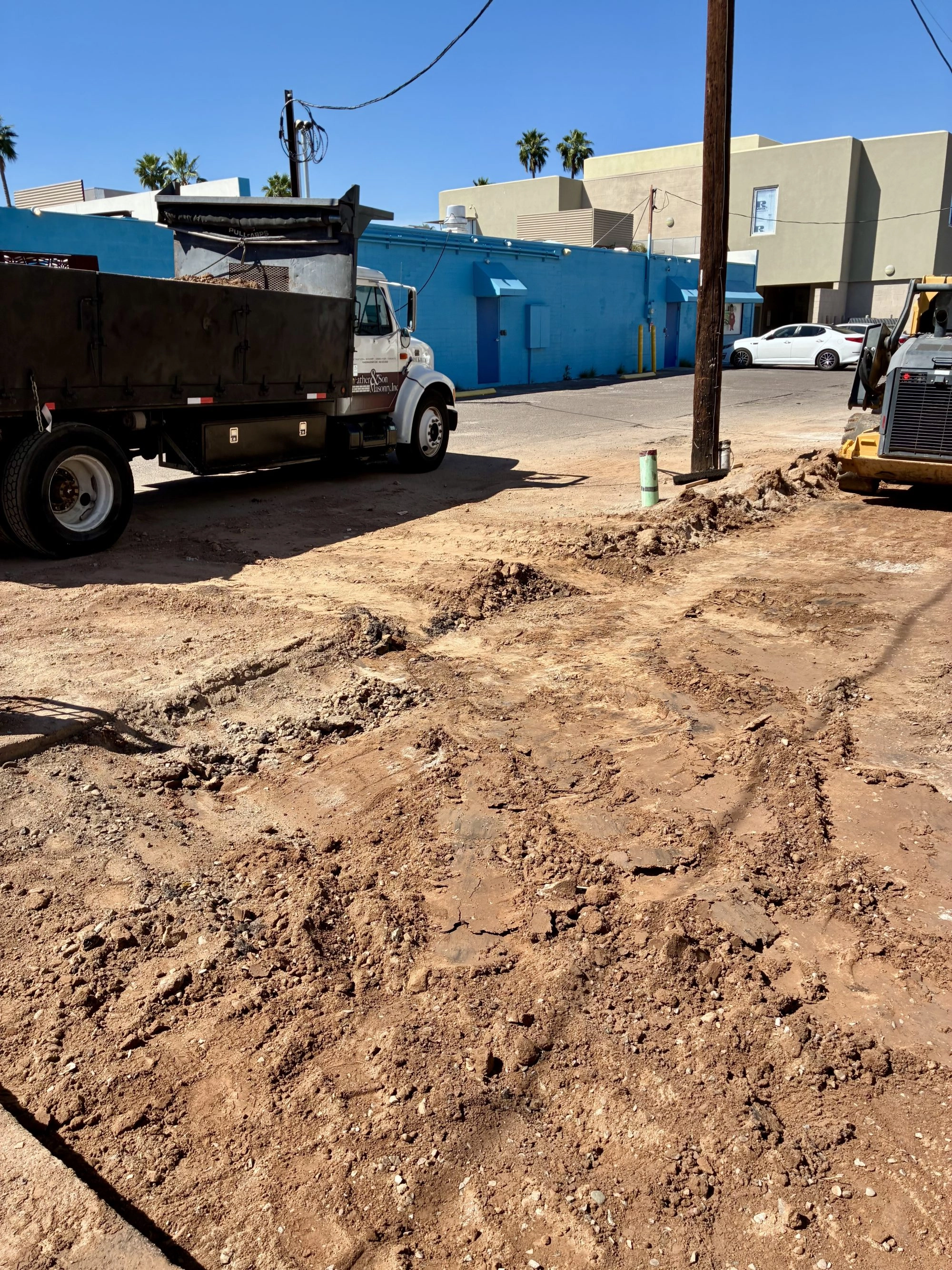 Father and Son Masonry dump truck on site during demolition phase of Reformed Pilates renovation Scottsdale AZ