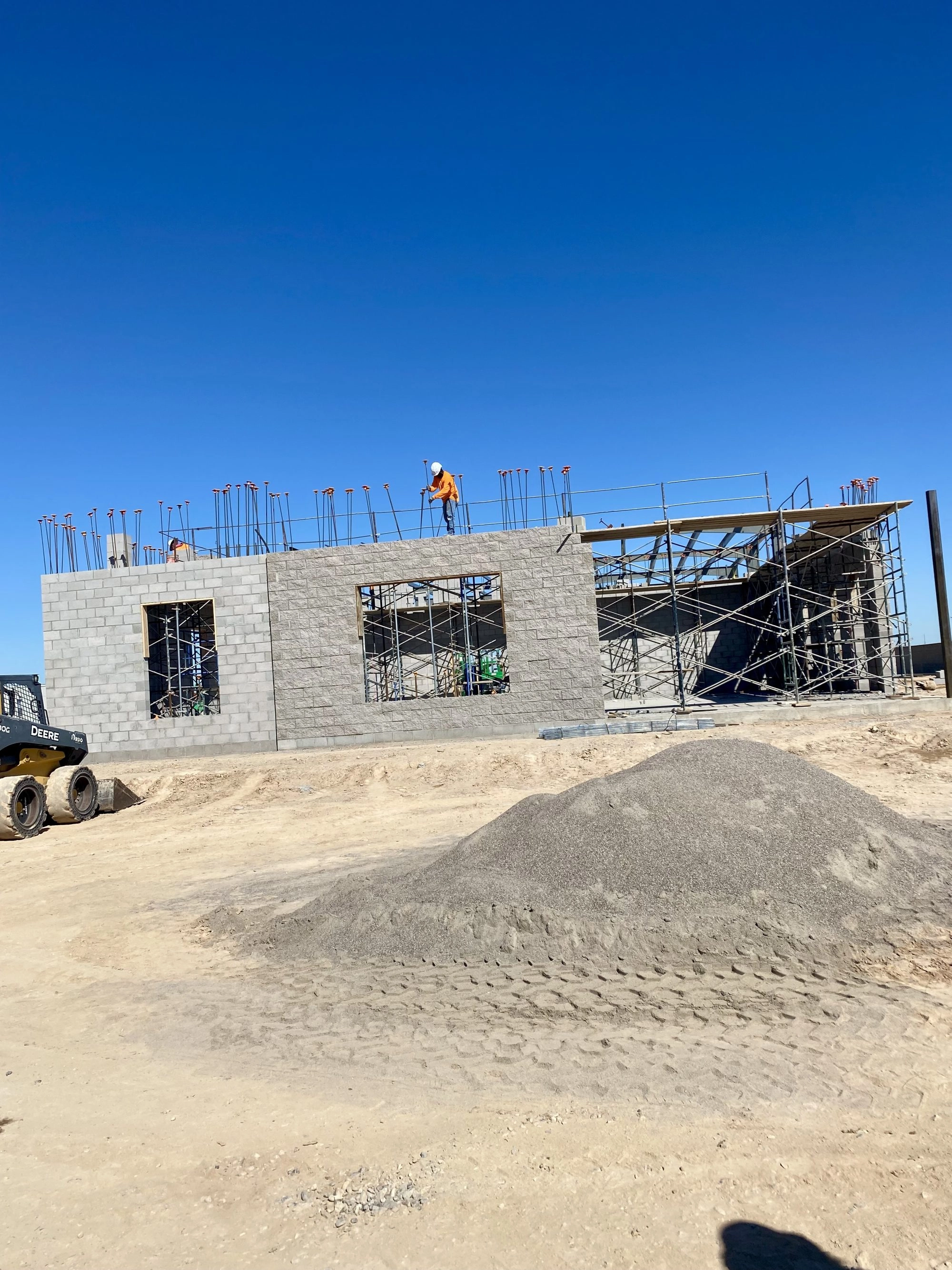 Father and Son Masonry crew building CMU block walls with scaffolding at Sunbelt Rentals El Mirage AZ