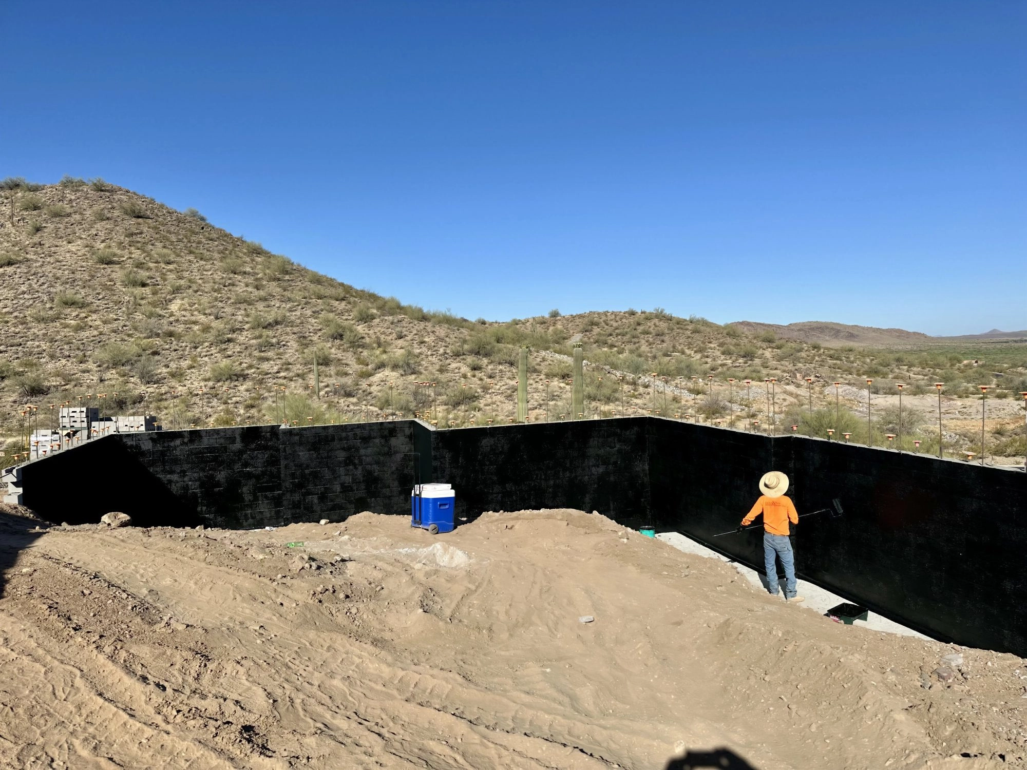 Father and Son Masonry crew applying waterproofing membrane to CMU retaining walls in Glendale AZ