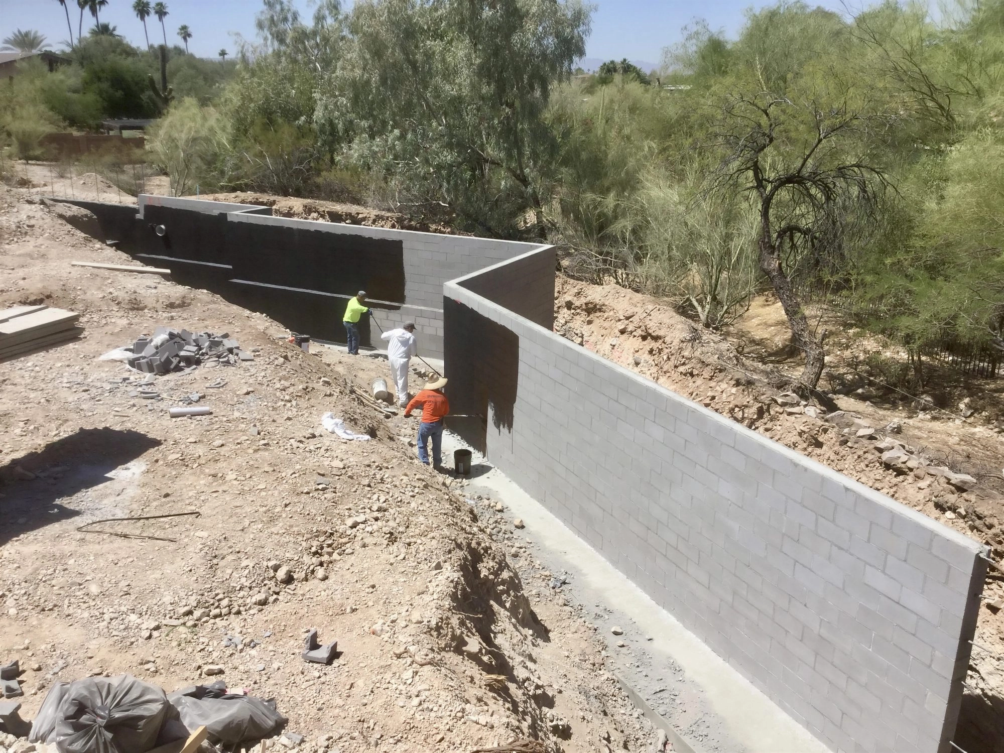 Waterproofed CMU retaining walls under construction on hillside residential property in Phoenix AZ by Father and Son Masonry