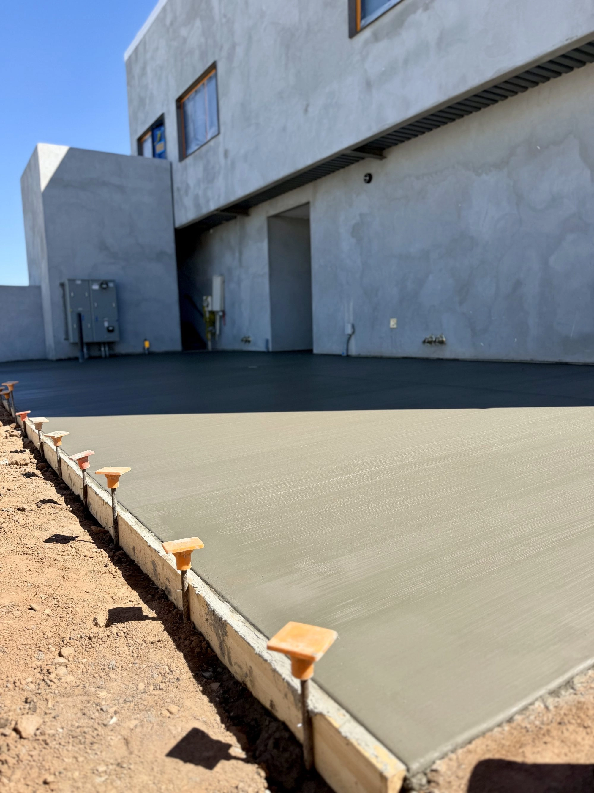 Smooth broom finish concrete flatwork pour next to Reformed Pilates building in Old Town Scottsdale AZ