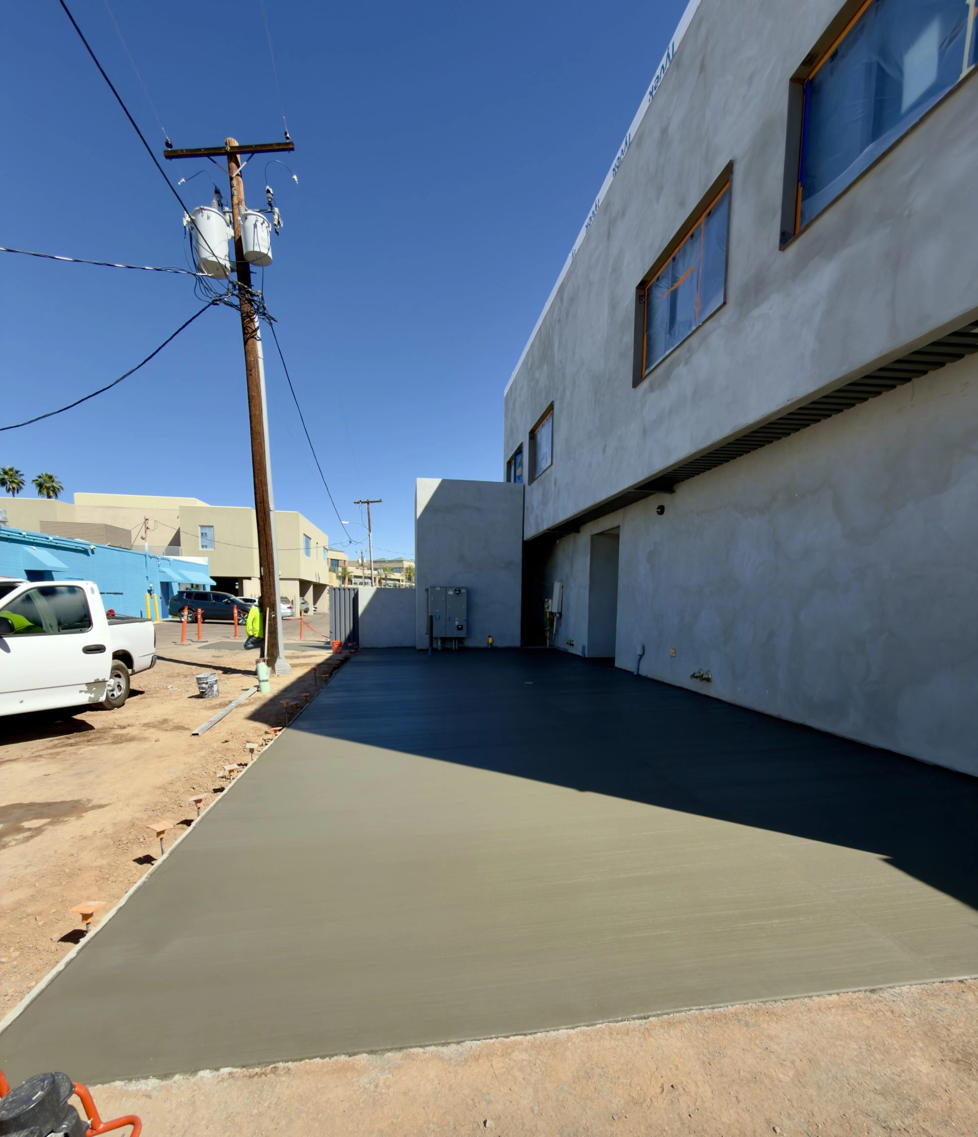 Aerial view of finished exterior concrete flatwork surrounding Reformed Pilates two story building in Scottsdale AZ