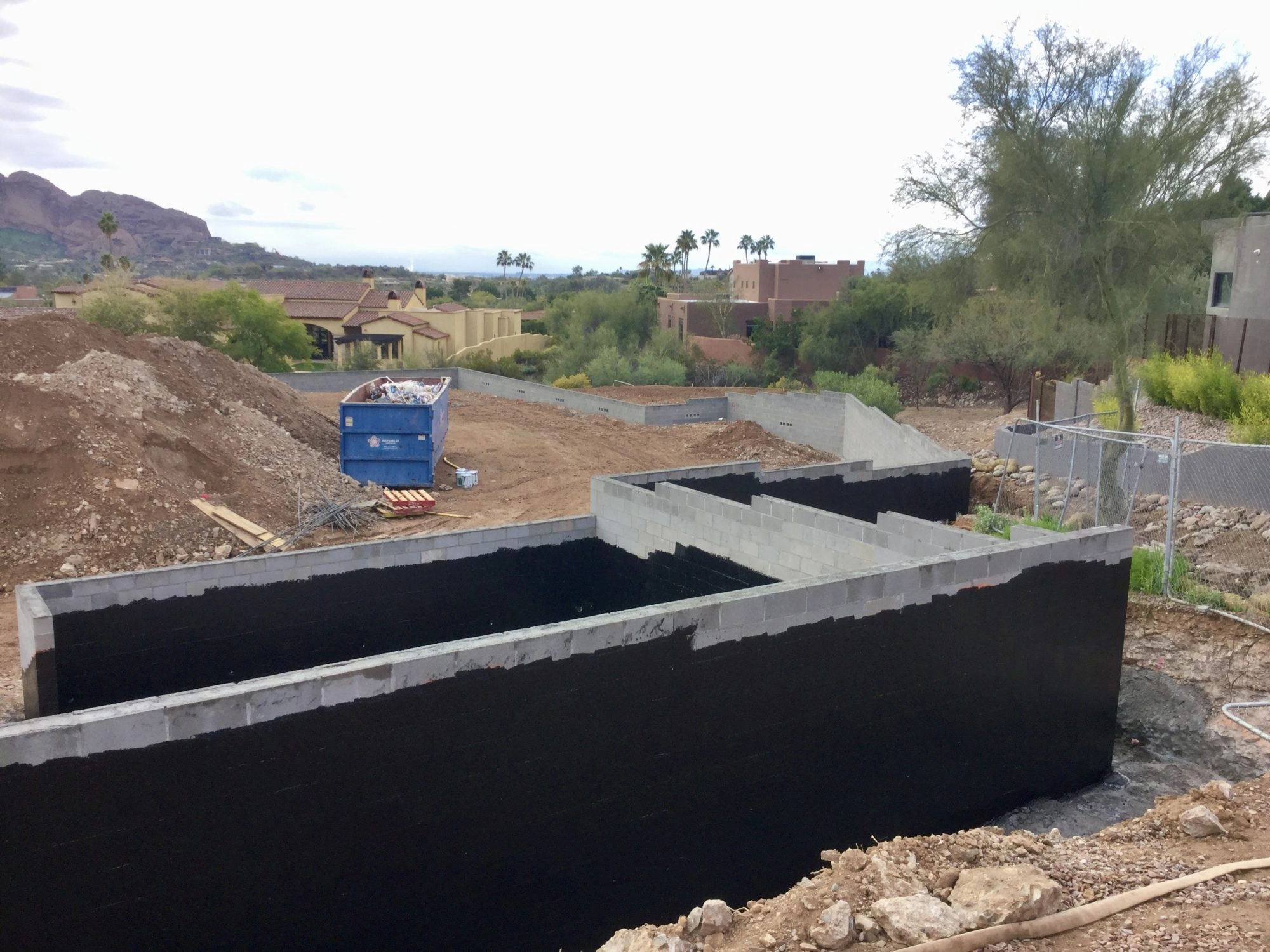 Hillside CMU retaining wall with completed concrete slab and waterproofing in Phoenix AZ